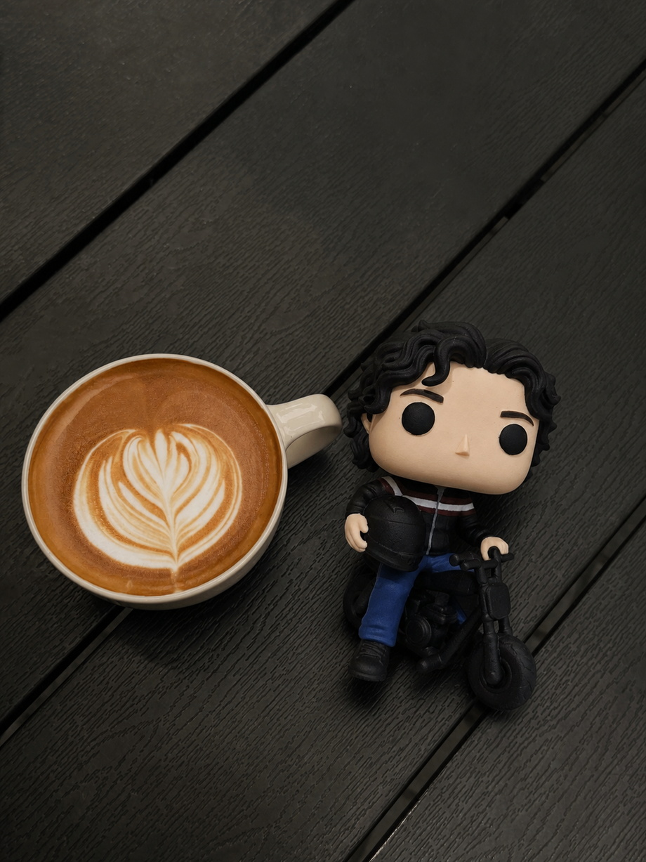 Custom biker figurine on a motorcycle beside a latte with leaf art - JuJuBit