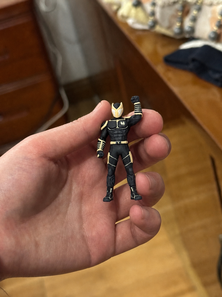 Custom masked superhero figurine in a black and gold suit with fist raised - JuJuBit